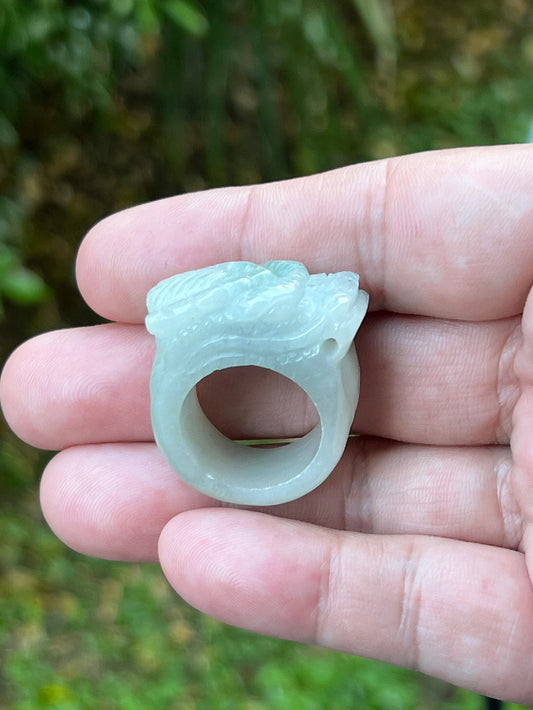 Close-up of layered body and scale detailing on a hand-carved dragon motif semi-translucent icy bluish-white Burmese jade ring