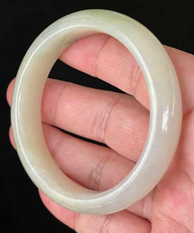 Close-up of fine crystalline texture and natural stone vines on icy yellow and white jadeite bangle