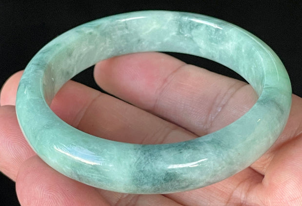 Close-up of fine crystalline texture and beautiful moss in the snow pattern on icy imperial green and white jadeite bangle