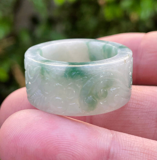 Close-up of continuous flowing swirl patterns and fine-grained texture on an icy imperial green Burmese jade ring