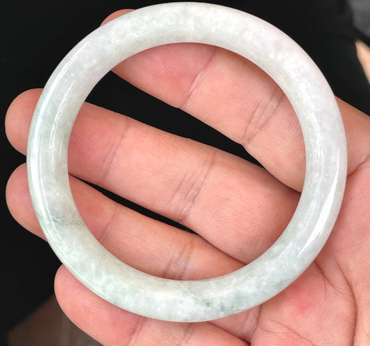 Solid icy white and apple green natural Type A Burmese jade bangle bracelet in a flat round style, size 56.5mm