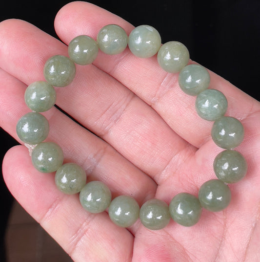 Hand-shaped 10.4mm natural Type A Burmese jade beads showing a serene icy green color on the wrist