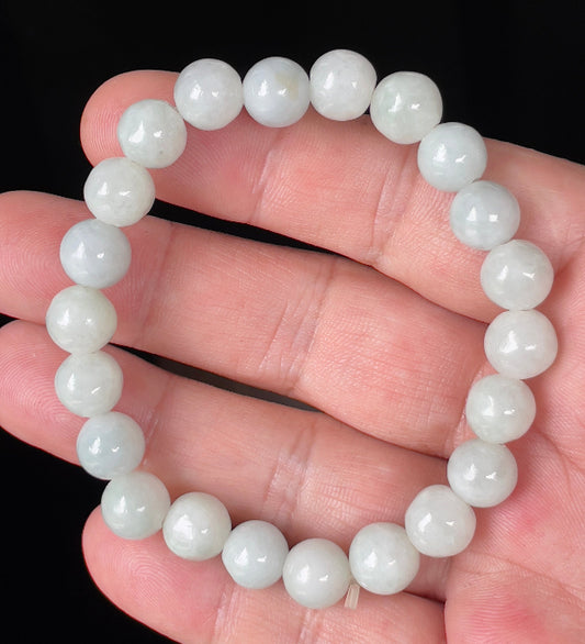 Hand-shaped 9.7mm natural Type A Burmese jade beads showing gentle translucency with icy green and white colors on the wrist