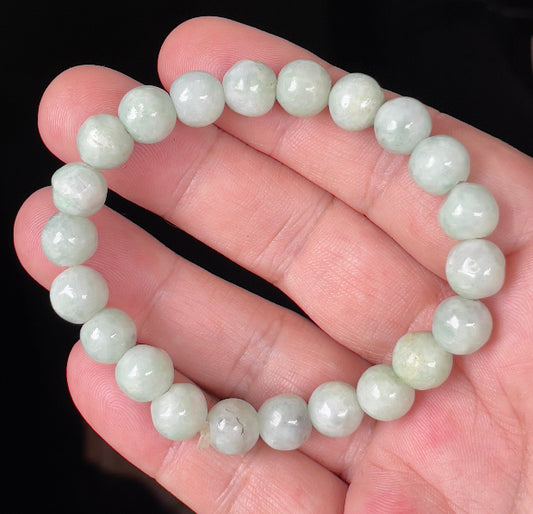 Hand-shaped 9.5mm natural Type A Burmese jade beads showing gentle translucency and icy green colors on the wrist