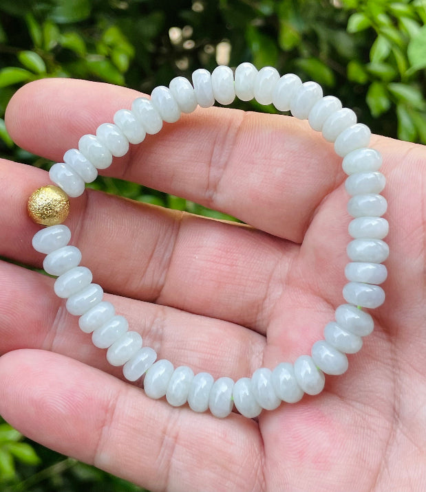 Handcrafted genuine Grade A Burmese jadeite stretch bracelet showcasing beautiful icy apple green rondelle beads and a matte-textured golden bead