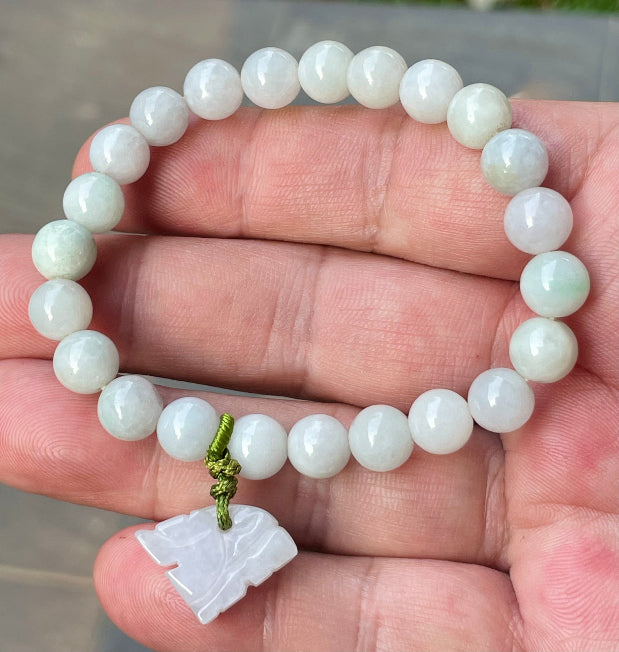 Handcrafted genuine Grade A Burmese jadeite stretch bracelet showcasing beautiful milky white and icy apple green beads with a hand-carved tiger pendant