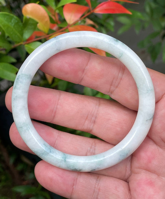 Solid icy imperial green and milky white natural Type A Burmese jade bangle bracelet in size 59mm