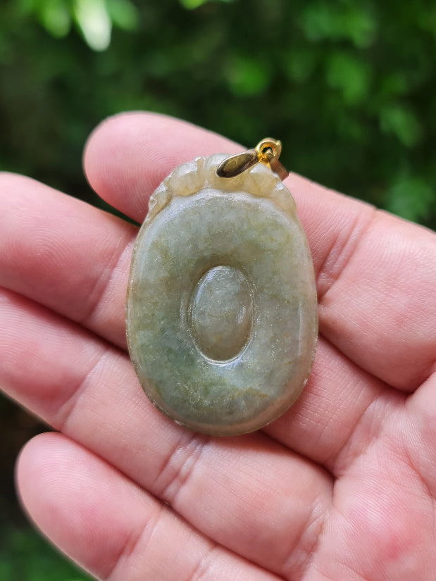 Untreated Type A Burmese jade pendant showing a smooth polished finish with beautiful imperial green and warm honey tones