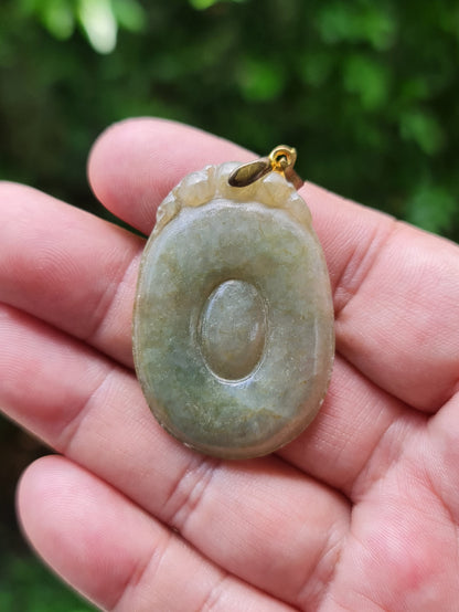 Untreated Type A Burmese jade pendant showing a smooth polished finish with beautiful imperial green and warm honey tones