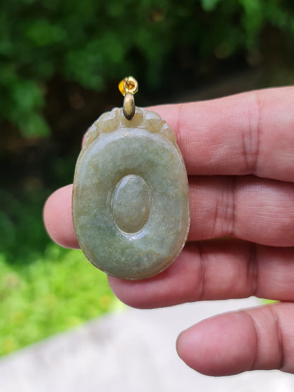 Untreated Type A Burmese jade pendant showing a smooth polished finish with beautiful imperial green and warm honey tones