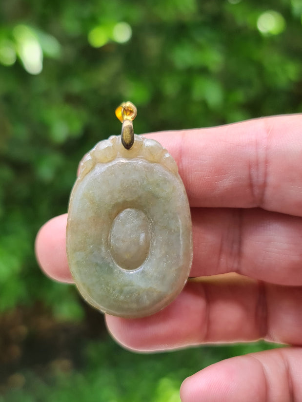 Untreated Type A Burmese jade pendant showing a smooth polished finish with beautiful imperial green and warm honey tones