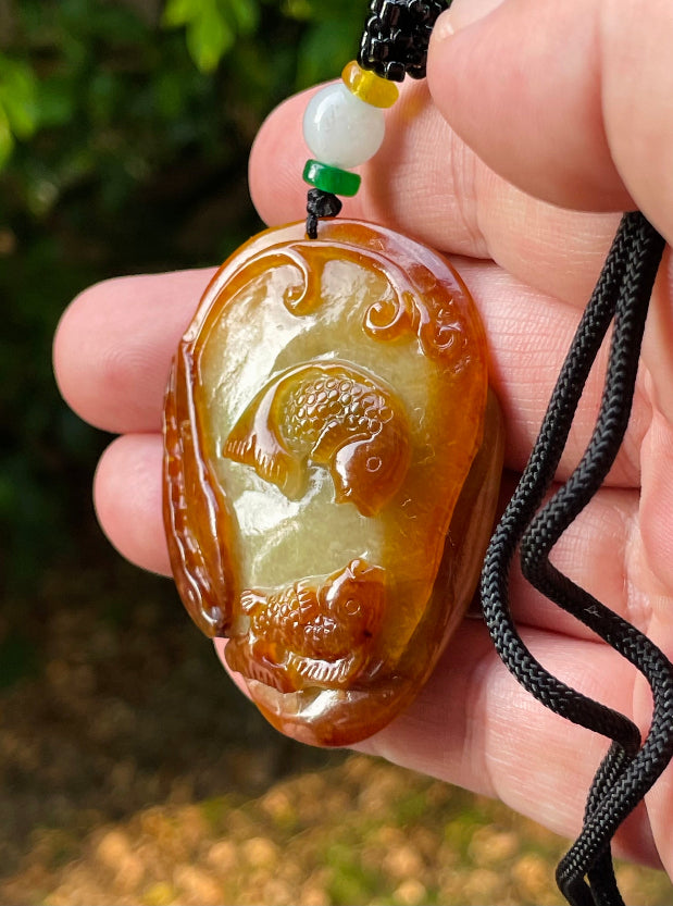 Vitreous luster and fine texture of the authentic Myanmar jade pendant JP080 showcasing a carved twin fish Feng Shui design for abundance and happiness