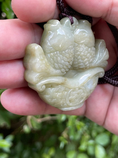 Glossy luster and medium texture of the authentic Myanmar jade pendant JP038 showcasing a carved twin fish Feng Shui design for wealth and abundance