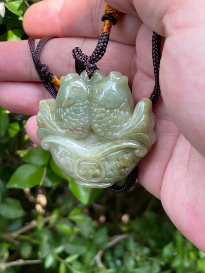 Glossy luster and medium texture of the authentic Myanmar jade pendant JP038 showcasing a carved twin fish Feng Shui design for wealth and abundance