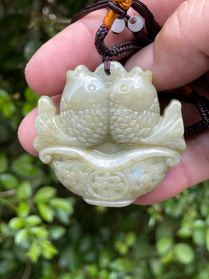 Glossy luster and medium texture of the authentic Myanmar jade pendant JP038 showcasing a carved twin fish Feng Shui design for wealth and abundance