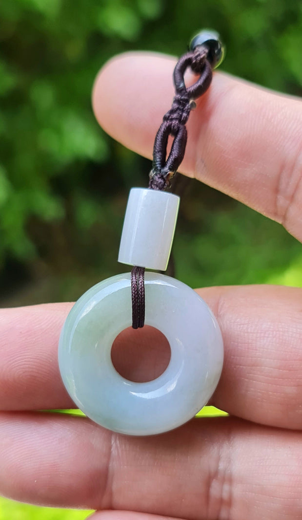 Vitreous luster and fine texture of the authentic Myanmar jade pendant JP024 showcasing a classic donut swirl Feng Shui design for unity and peace