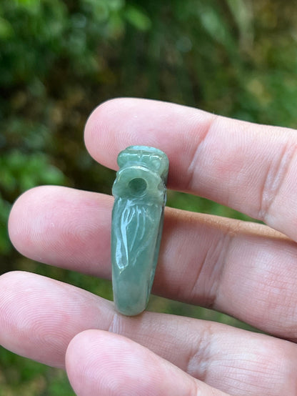 Close-up of dimensional and expressive dragon carving on a semi-translucent apple green Burmese jade ring