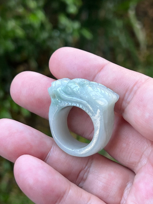 Close-up of layered body and scale detailing on a hand-carved dragon motif semi-translucent icy bluish-white Burmese jade ring