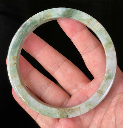 Close-up of fine crystalline texture and moss in the snow effect on icy mixed green and white jadeite bangle