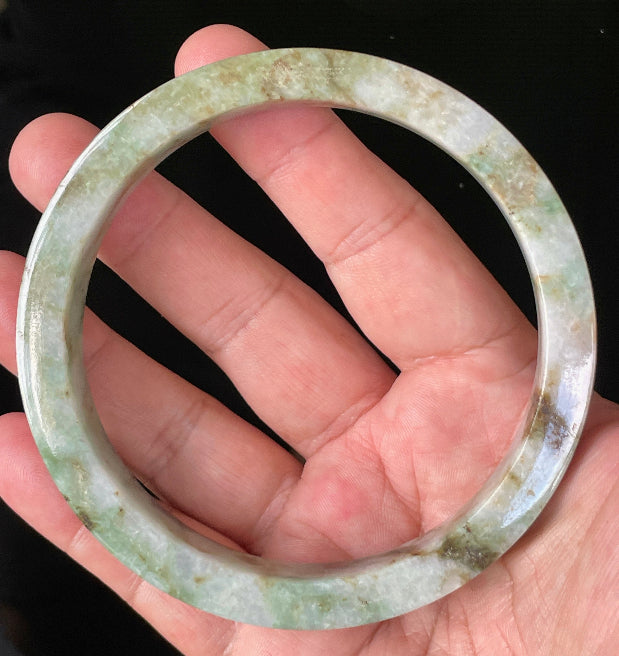 Close-up of fine crystalline texture and moss in the snow effect on icy mixed green and white jadeite bangle