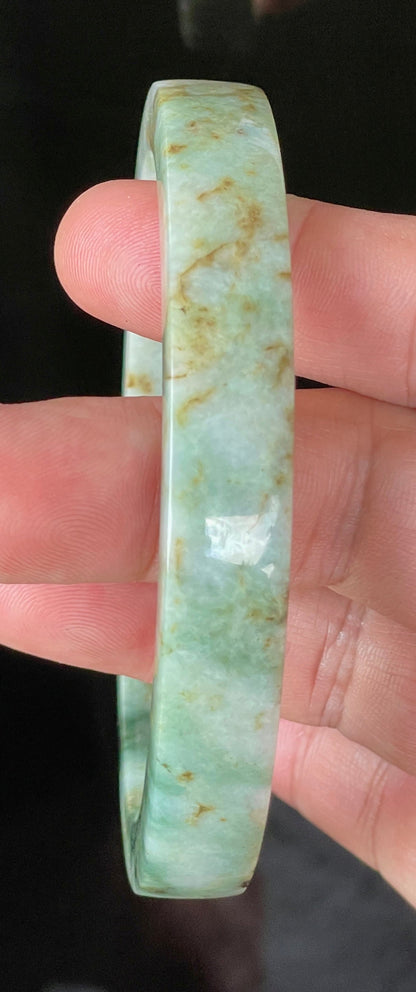 Close-up of fine crystalline texture and moss in the snow effect on icy mixed green and white jadeite bangle