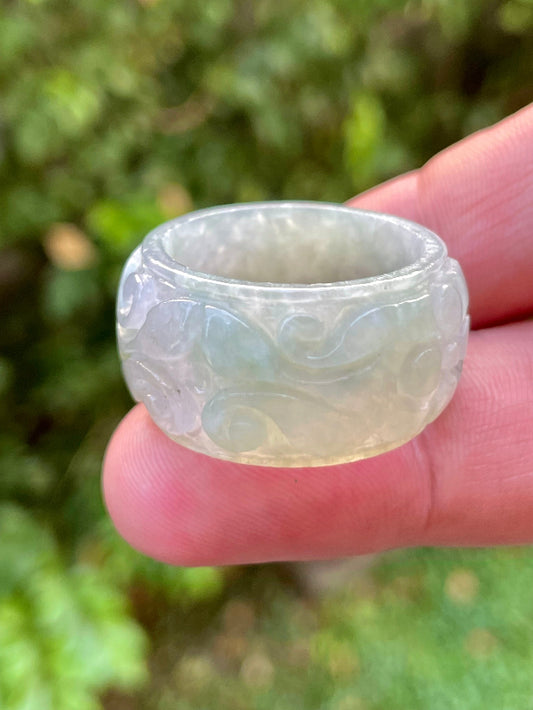 Close-up of skillfully sculpted curves and blooms on an icy white and imperial green Burmese jade ring