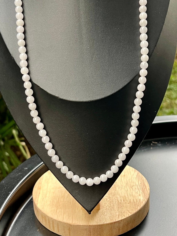 Woman wearing a 23-inch elegant natural Grade A jade bead necklace with a red-tone twist clasp