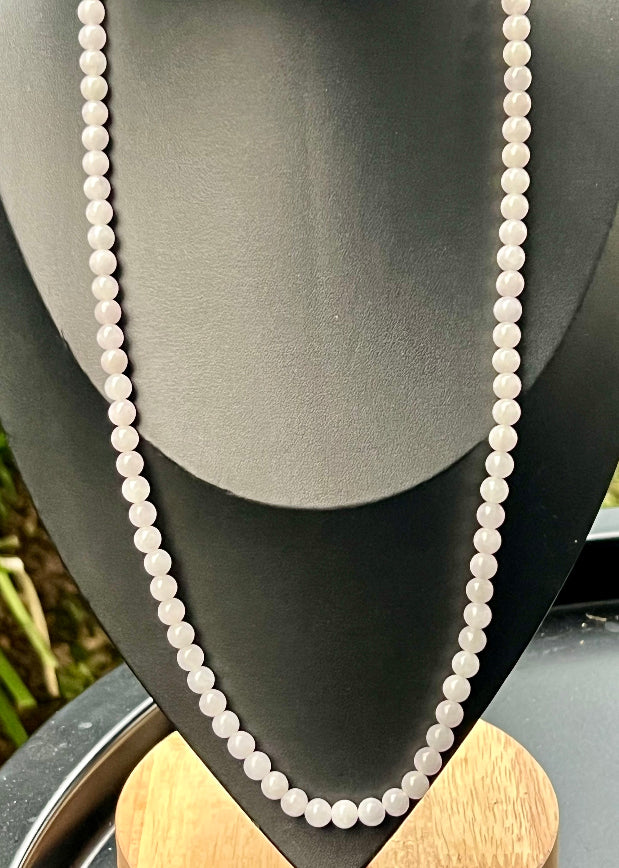 Woman wearing a 23-inch elegant natural Grade A jade bead necklace with a red-tone twist clasp