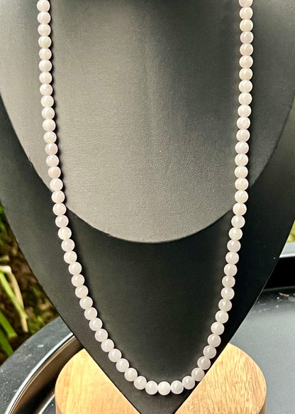 Woman wearing a 23-inch elegant natural Grade A jade bead necklace with a red-tone twist clasp