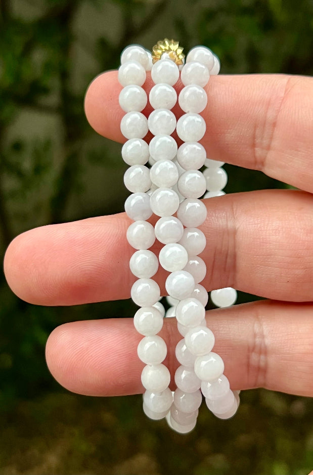 Woman wearing a 23-inch elegant natural Grade A jade bead necklace with a red-tone twist clasp