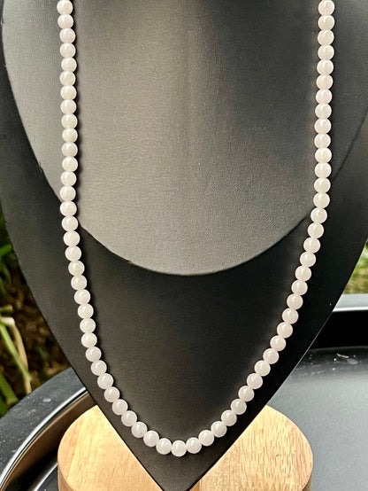 Woman wearing a 23-inch elegant natural Grade A jade bead necklace with a red-tone twist clasp