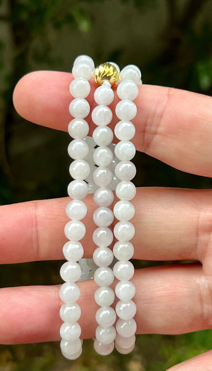 Woman wearing a 23-inch elegant natural Grade A jade bead necklace with a red-tone twist clasp