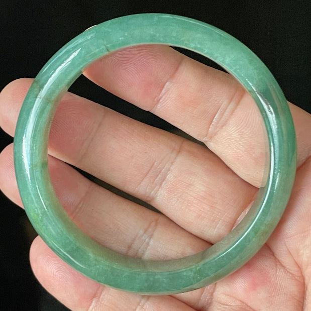 Close-up of fine crystalline texture and rare honey brown hues on icy apple and emerald green jadeite bangle