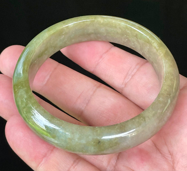 Close-up of fine crystalline texture and vibrant forest green hues on icy apple green and honey white jadeite bangle