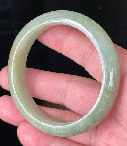 Close-up of fine crystalline texture and honey hues on icy apple green and milky white jadeite bangle