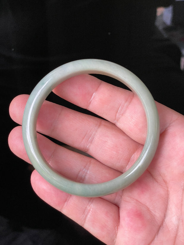 Close-up of fine crystalline texture and warm honey hues on icy bluish white jadeite bangle