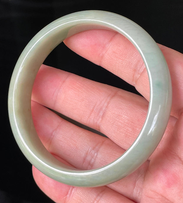 Close-up of fine crystalline texture and warm honey hues on icy bluish white jadeite bangle