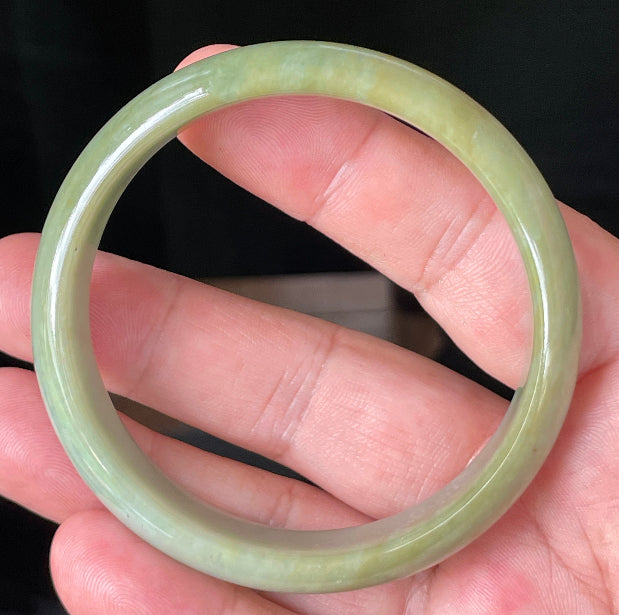 Close-up of fine crystalline texture and warm honey hues on icy bluish white jadeite bangle