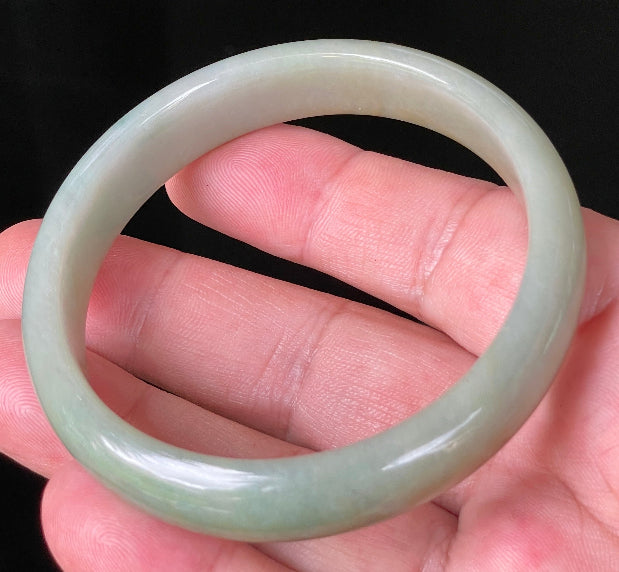 Close-up of fine crystalline texture and warm honey hues on icy bluish white jadeite bangle