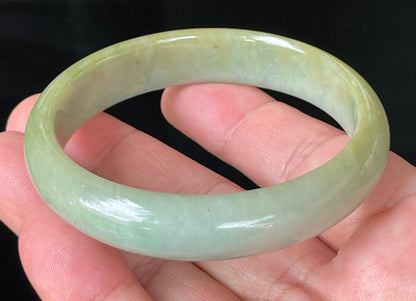 Close-up of fine crystalline texture and warm honey hues on icy bluish white jadeite bangle