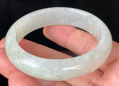 Close-up of fine crystalline texture and distinctive imperial green dots on icy apple green and white jadeite bangle