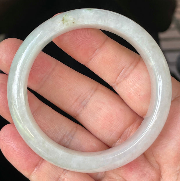 Close-up of fine crystalline texture and distinctive imperial green dots on icy apple green and white jadeite bangle