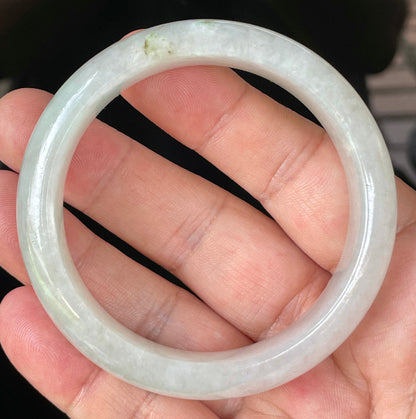 Close-up of fine crystalline texture and distinctive imperial green dots on icy apple green and white jadeite bangle