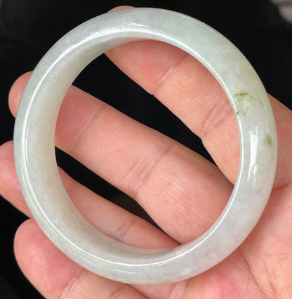 Close-up of fine crystalline texture and distinctive imperial green dots on icy apple green and white jadeite bangle