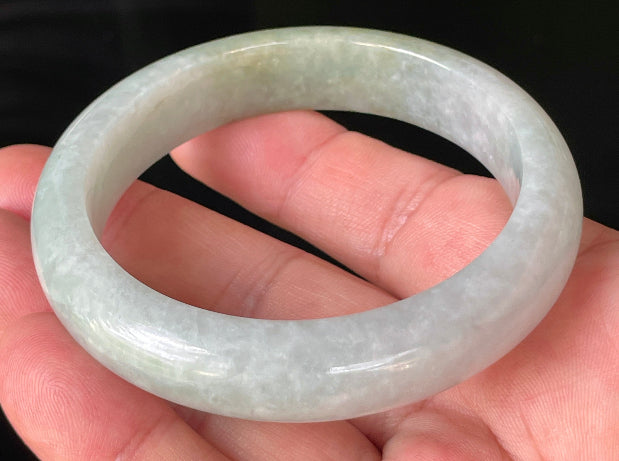 Close-up of fine crystalline texture and delicate lavender hues on icy greyish white and green jadeite bangle