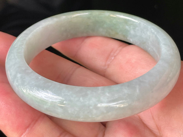 Close-up of fine crystalline texture and delicate lavender hues on icy greyish white and green jadeite bangle