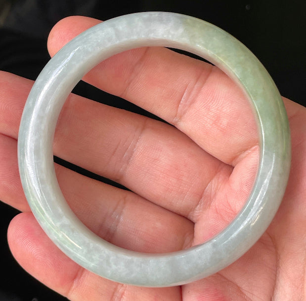 Close-up of fine crystalline texture and delicate lavender hues on icy greyish white and green jadeite bangle