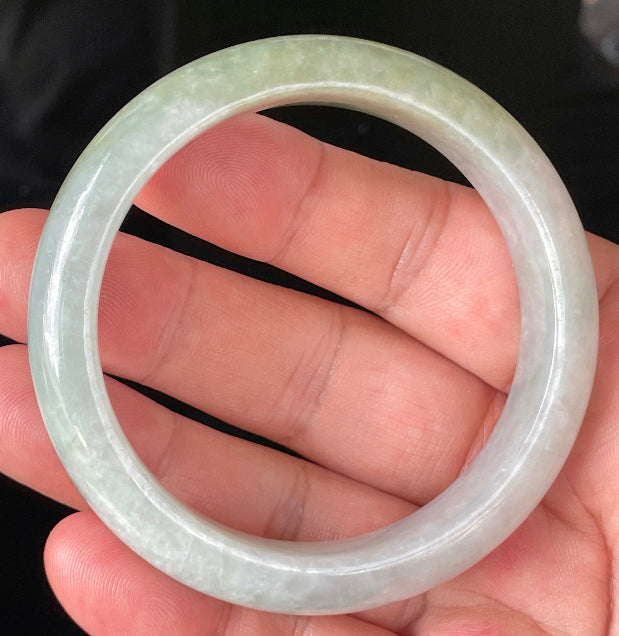 Close-up of fine crystalline texture and delicate lavender hues on icy greyish white and green jadeite bangle