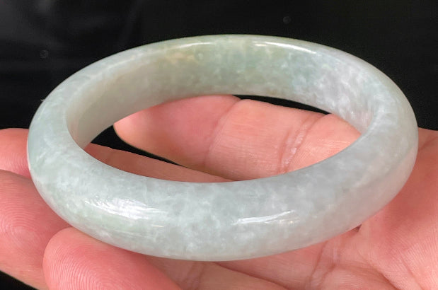 Close-up of fine crystalline texture and delicate lavender hues on icy greyish white and green jadeite bangle