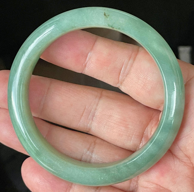 Close-up of fine crystalline texture and vivid imperial green hues on icy apple green jadeite bangle